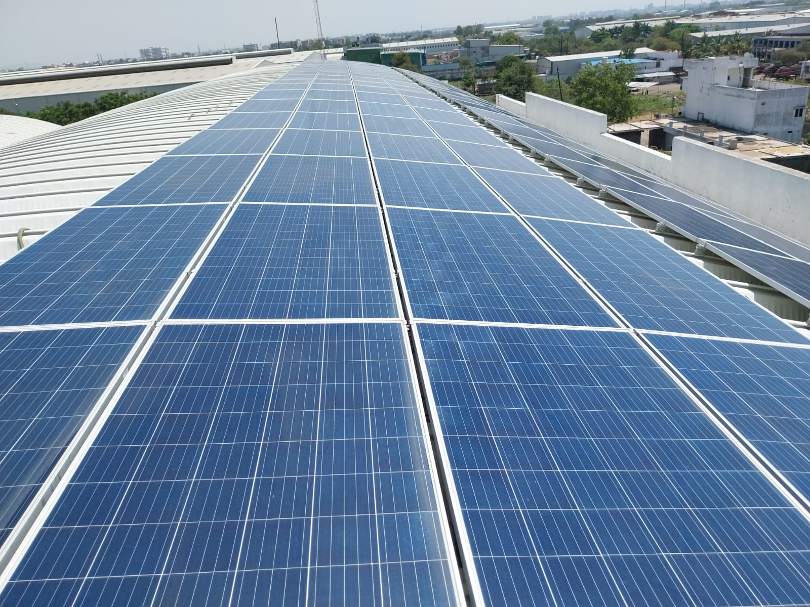 Industrial rooftop solar panel installation on factory building shed