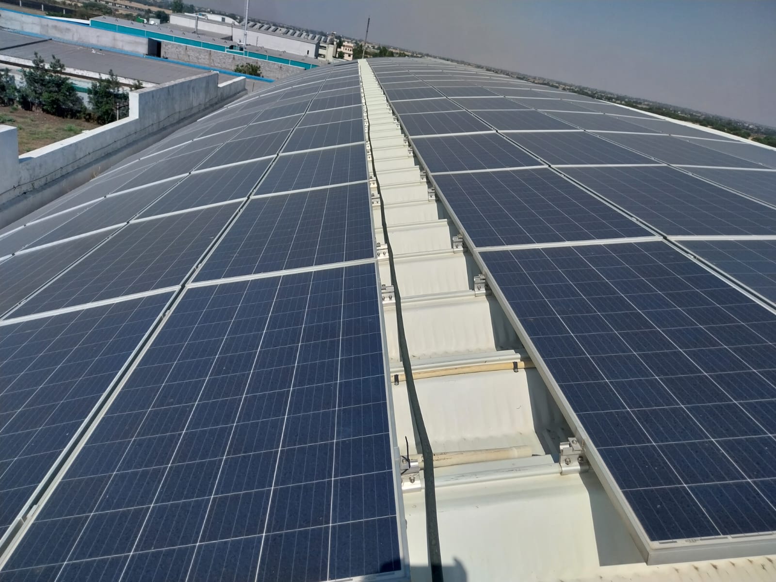 Commercial solar panel plant installed on curved warehouse roof